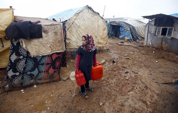 Девочка несет воду в лагере сирийских беженцев близ Баб аль-Салам (Сирия) недалеко от границы с Турцией. - Sputnik Грузия