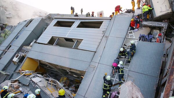 Спасатели проводят поисковые работы на месте обрушения 17-этажного здания после землетрясения в Тайнане (юг Тайвая). - Sputnik Грузия