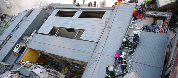 Спасатели проводят поисковые работы на месте обрушения 17-этажного здания после землетрясения в Тайнане (юг Тайвая). - Sputnik Грузия