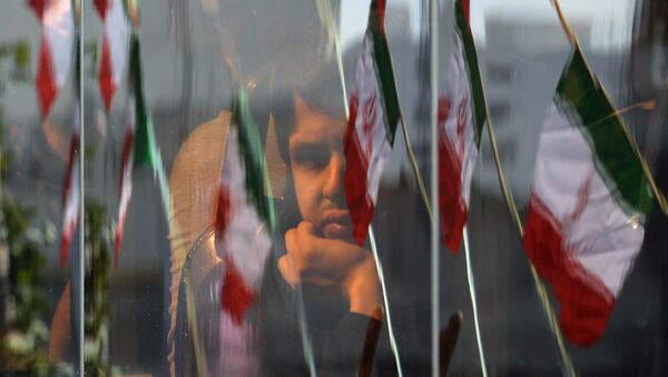 Житель Ирана выглядывает из окна автобуса в Тегеране во время празднования Дня Исламской революции. - Sputnik Грузия