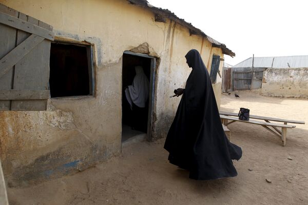 Женщина-шиитка входит в классную комнату в местной исламской школе в Заре, Нигерия. Тут растет напряженность после того, как сотни шиитов были убиты в ходе столкновений с правительственными войсками, а их святыни и кладбища разрушены бульдозерами. - Sputnik Грузия