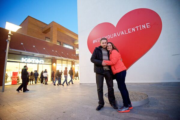 Влюбленная пара в День Святого Валентина фотографируется на память у большого сердца на территории одного из торговых центров грузинской столицы. - Sputnik Грузия