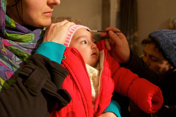 Девочке наносят на лоб миро в квартире семьи Какошвили, где мироточат иконы. - Sputnik Грузия