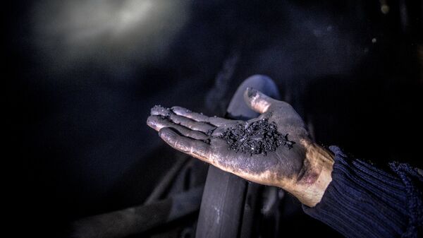 Шахтер показывает уголь на шахте - Sputnik Грузия