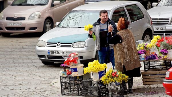 Мужчина покупает цветы у уличной продавщицы - Sputnik Грузия