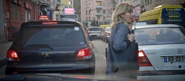 Женщина перебегает дорогу между машинами в Тбилиси Женщина перебегает дорогу между машинами в Тбилиси - Sputnik Грузия