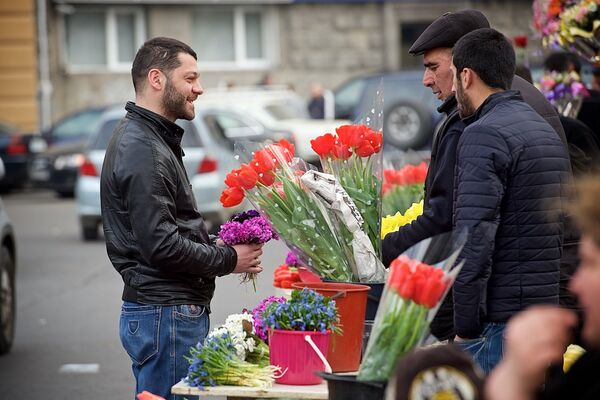 Мужчина выбирает цветы в подарок на цветочном базаре в центре грузинской столицы. - Sputnik Грузия