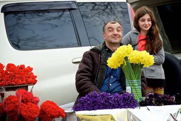 Мужчина, торгующий цветами на цветочном рынке, вместе со своей дочерью радуются празднику 8 марта. - Sputnik Грузия