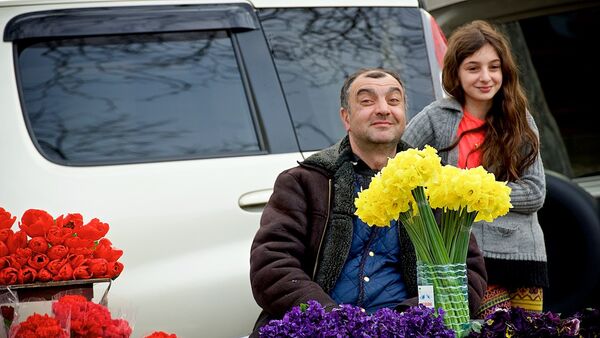 Мужчина, торгующий цветами на цветочном рынке, вместе со своей дочерью радуется празднику 8 марта. - Sputnik Грузия