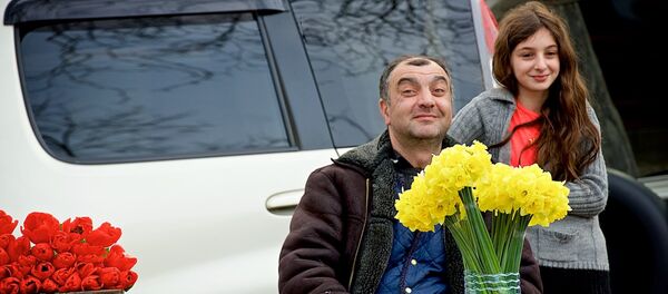 Мужчина, торгующий цветами на цветочном рынке, вместе со своей дочерью радуется празднику 8 марта. - Sputnik Грузия