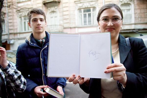 Поклонница творчества французского писателя показывает автограф, который ей оставил Фредерик Бегбедер. - Sputnik Грузия