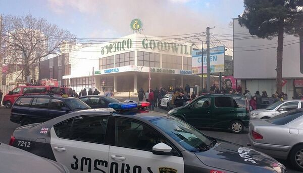 Полицейские машины и оцепление вокруг здания гипермаркета сети Гудвилл в центре Тбилиси, где произошел пожар. Фото очевидца. - Sputnik Грузия