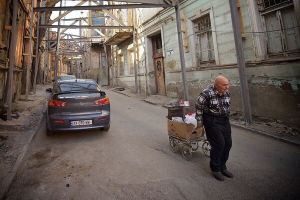 Мужчина, собирающий старые и ненужные вещи, спускается по улице Ахоспирели. - Sputnik Грузия