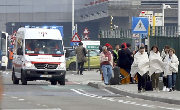 Машина скорой медицинской помощи и люди, покидающие международный аэропорт Брюсселя после взрыва. - Sputnik Грузия