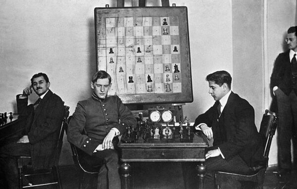 Кубинский шахматист, чемпион мира 1921-27гг. Х. Р. Капабланка и русский шахматист, чемпион мира 1929-35гг., 1937-46гг. А.А. Алехин (в центре справа налево) за шахматной партией. Кубинский шахматист, чемпион мира 1921-27гг. Х. Р. Капабланка и русский шахматист, чемпион мира 1929-35гг., 1937-46гг. А.А. Алехин (в центре справа налево) за шахматной партией. - Sputnik Грузия