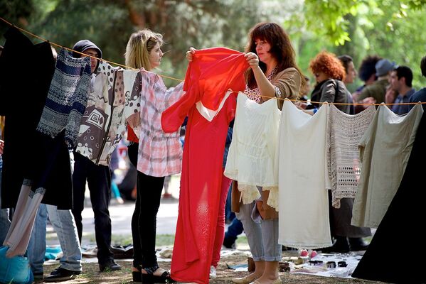 Женщина выбирает одежду на Тбилисском блошином рынке. - Sputnik Грузия