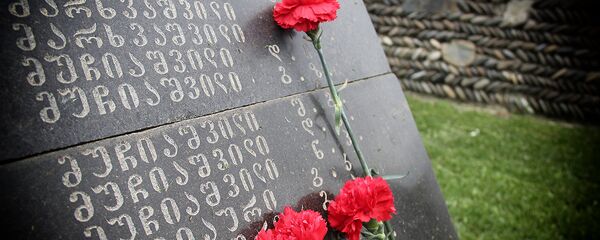 Цветы на надгробной плите на одном из братских кладбищ погибших в годы Второй мировой войны - Sputnik Грузия