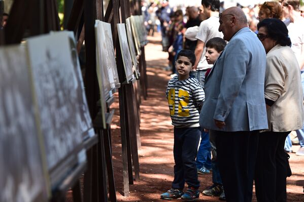 Люди рассматривают снимки военных лет на выставке фотографий, посвященных участию грузин в Великой Отечественной войне. Парк Ваке, 9 мая - Sputnik Грузия