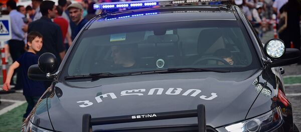 Жители столицы Грузии сидят на местах патрульных в полицейской машине - Sputnik Грузия
