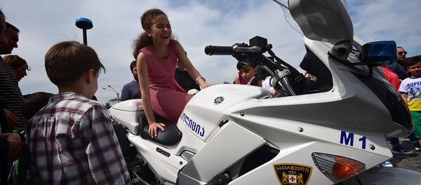 Дети фотографируются на полицейском мотоцикле во время празднования Дня Независимости Грузии Дети фотографируются на полицейском мотоцикле во время празднования Дня Независимости Грузии - Sputnik Грузия