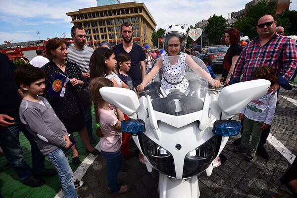 Люди фотографируются на фоне полицейского мотоцикла в День Независимости Грузии на стенде МВД - Sputnik Грузия