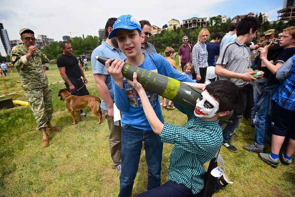 Дети держат муляж артиллерийского снаряда на военной выставке Минобороны Грузии. - Sputnik Грузия