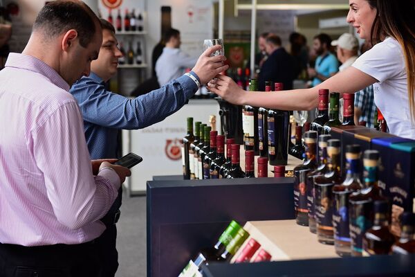 Представитель одной из винодельческих компаний предлагает гостям попробовать красное вино. - Sputnik Грузия