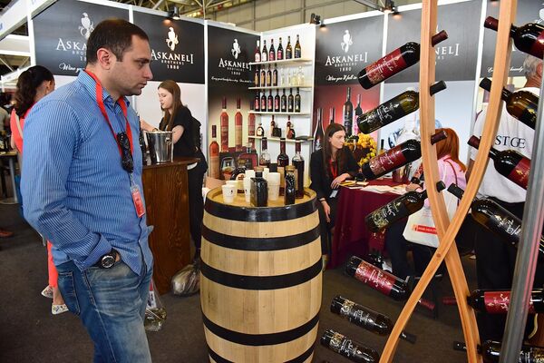 Посетитель выставки рассматривает стенд одной из винодельческих компаний Грузии. - Sputnik Грузия