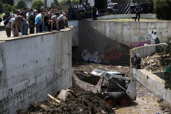 Жители Тбилиси и спасатели смотрят на разрушения и искореженные машины после наводнения в грузинской столице. - Sputnik Грузия