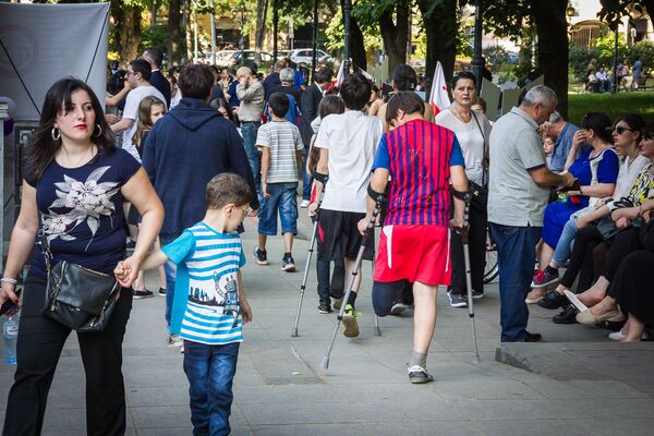 Множество людей заполнило парк в Тбилиси, где проходила развлекательная программа в парке с участием лиц с ОВЗ. - Sputnik Грузия