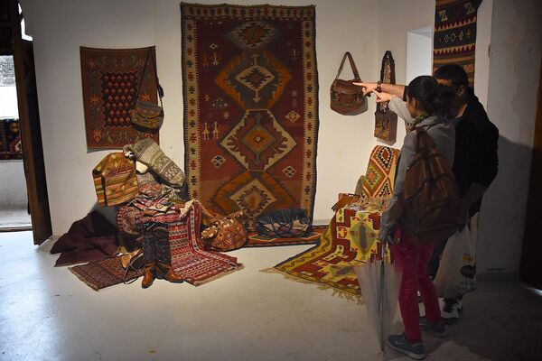 Посетители фестиваля рассматривают представленные на нем ковры. - Sputnik Грузия