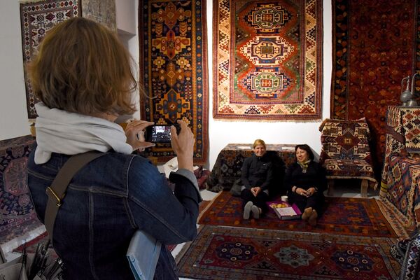 Посетительница выставки фотографирует участниц фестиваля ковров. - Sputnik Грузия
