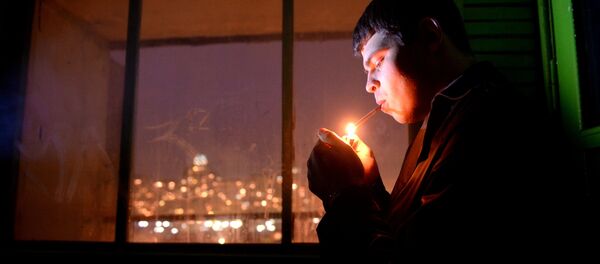 Молодой человек курит в подъезде жилого дома - Sputnik Грузия