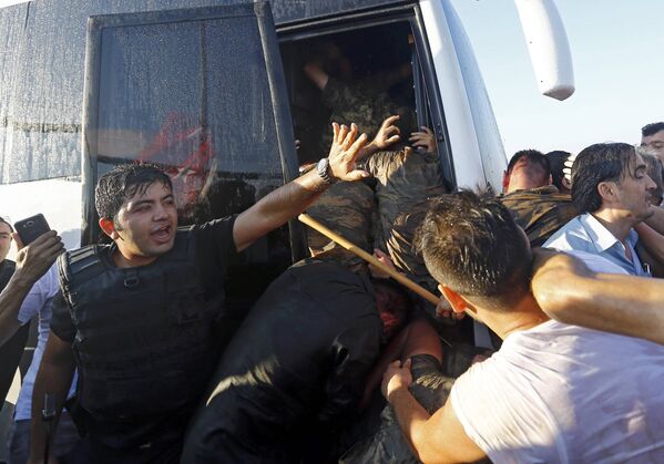 Полицейский сдерживает возмущенную толпу на мосту через Босфор, после освобождения его от мятежников. - Sputnik Грузия