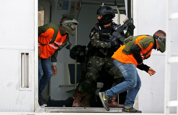 В ходе антитеррористических учений в Рио-де-Жанейро перед Олимпиадой. Служащий спецназа обеспечивает эвакуацию граждан из поезда метро в ходе предполагаемой атаки террористов. - Sputnik Грузия