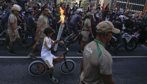 Житель Сан-Паулу несет олимпийский факел по улицам города в ходе эстафеты олимпийского огня. - Sputnik Грузия