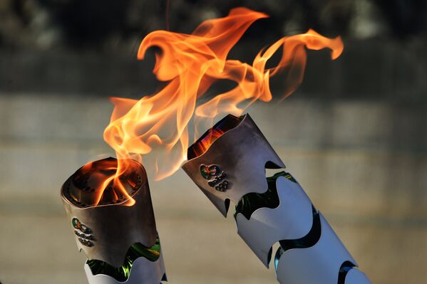 Жители Бразилии передают друг другу олимпийский огонь, зажигая факелы, в ходе эстафеты олимпийского огня. Парк Независимости в Сан-Паулу, Бразилия. - Sputnik Грузия