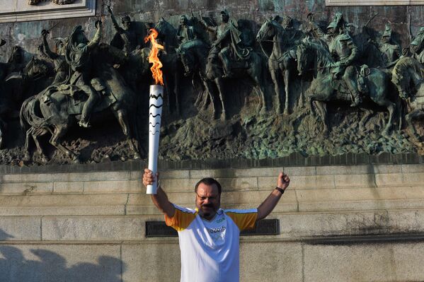 Житель Бразилии несет олимпийский факел на фоне Памятника Независимости в городе Сан-Паулу в ходе эстафеты олимпийского огня. Бразилия. - Sputnik Грузия