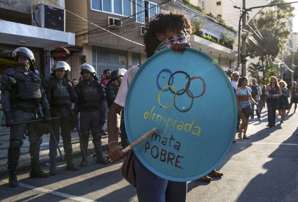 Участник акции протеста против Олимпиады на фоне полицейского кордона, неподалеку от стадиона Маракана. - Sputnik Грузия