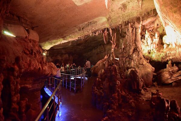 Центром пещеры можно назвать сталагмит в виде сердца. Туристы опускают руки в его углубления и загадывают желания. Центром пещеры можно назвать сталагмит в виде сердца. Туристы опускают руки в его углубления и загадывают желания. - Sputnik Грузия