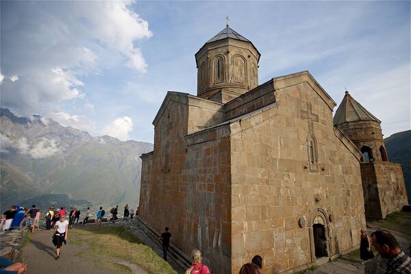 Туристы на территории церкви Святой Троицы на вершине горы у села Гергети. - Sputnik Грузия