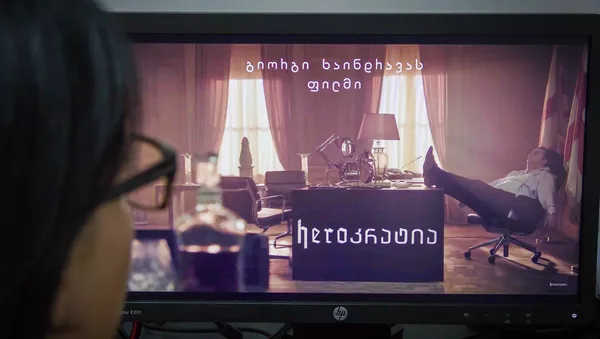 Девушка смотрит рекламный ролик политического сериала HeroKратия - Sputnik Грузия