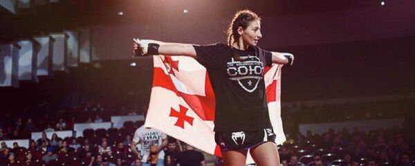 Лиана Джоджуа держит грузинский флаг после соревнований по ММА - Sputnik Грузия