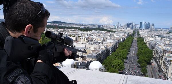 Снайпер занимает свою позицию в верхней части Триумфальной арки во время ежегодного военного парада в День взятия Бастилии на Елисейских полях в Париже - Sputnik Грузия