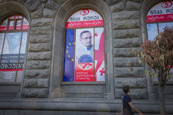 Предвыборный плакат одной из оппозиционных партий, размещенный в оконном проеме в здании в центре столицы Грузии. - Sputnik Грузия
