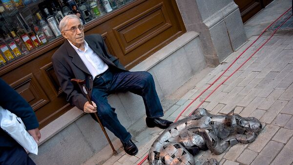 Пожилой мужчина отдыхает, сидя рядом со скульптурой собаки на проспекте Агмашенебели - Sputnik Грузия