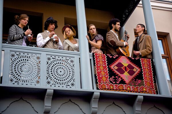 Молодые люди в старинной одежде на балконе одного из домов на проспекте Агмашенебели. - Sputnik Грузия