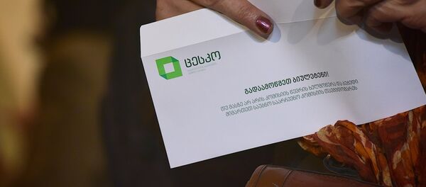 Женщина держит в руках бюллетень для голосования - Sputnik Грузия