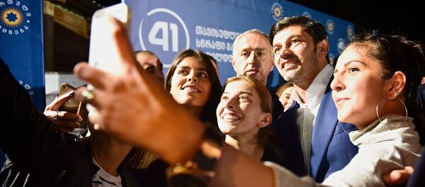 Сторонники Грузинской мечты снимают селфи вместе с главой избирательного штаба партии Кахой Каладзе (второй справа) - Sputnik Грузия