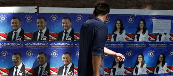 Человек проходит мимо предвыборных плакатов - Sputnik Грузия